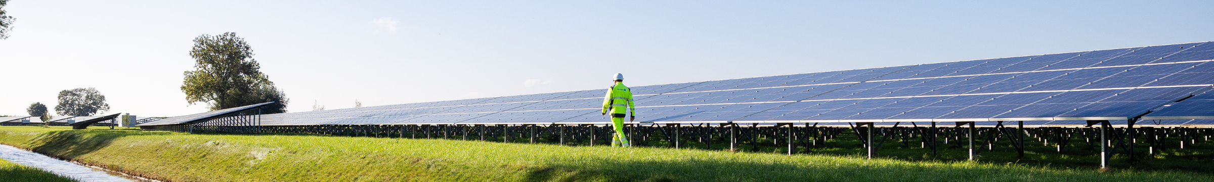Man walking next to a solar panel